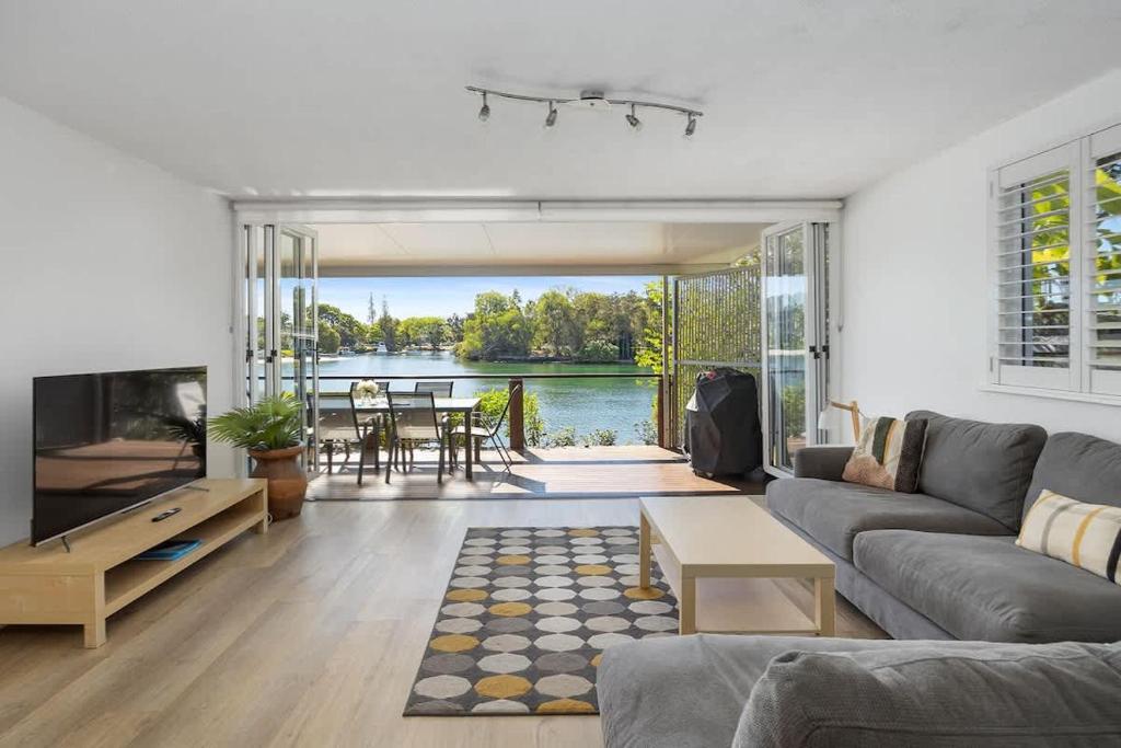 a living room with a couch and a tv at Noosa Haven Apt 6 Riverside Retreat in Noosaville