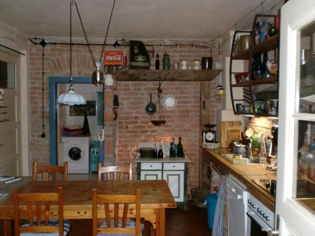 eine Küche mit einem Holztisch und einer Ziegelwand in der Unterkunft Anno-Nostalgia in Rheinsberg