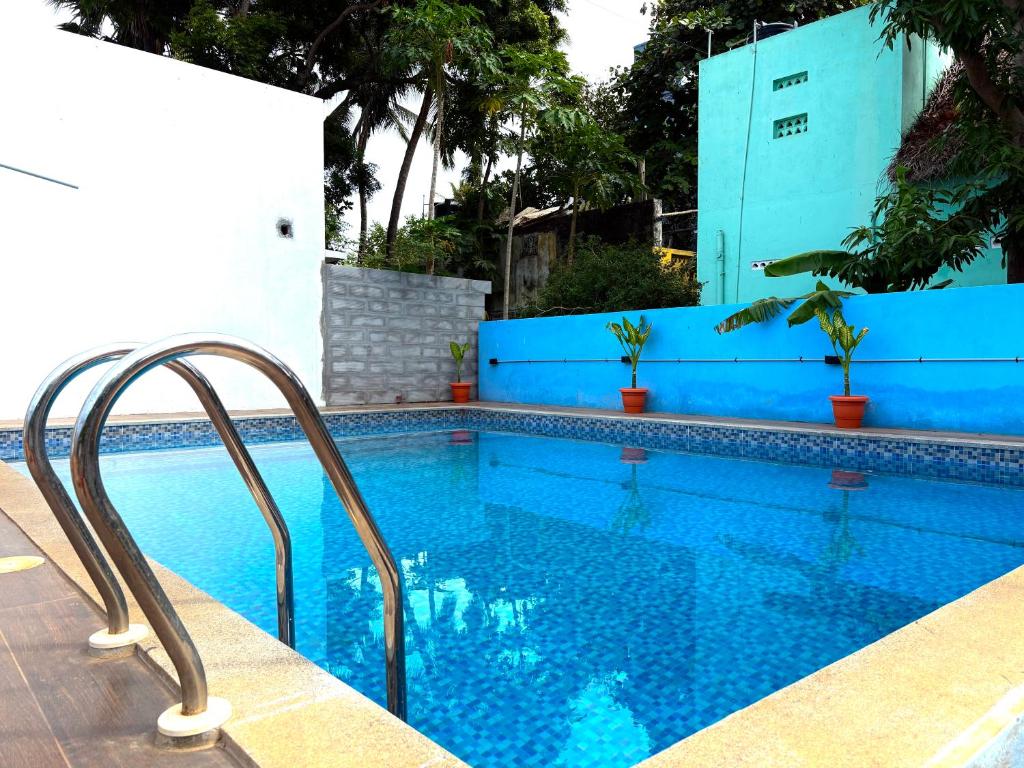 a swimming pool with a blue wall and a blue swimming pooliterator at DPD Beach Hotel in Pondicherry