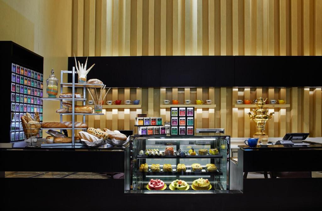 A bakery counter displays breads, pastries, cakes, and packaged goods at VE Hotel & Residence.
