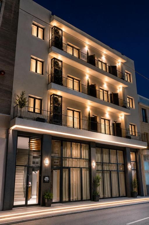 a large white building with windows at night at Corto Maltese Boutique in Athens