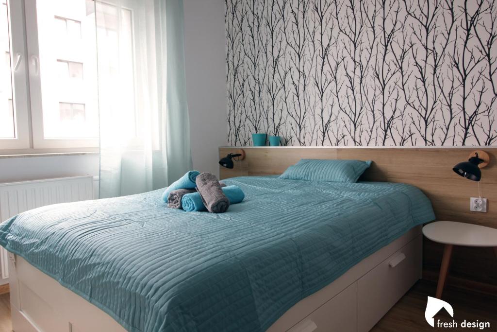 a bedroom with a bed with a stuffed animal on it at Apartament nad Odrą in Wrocław