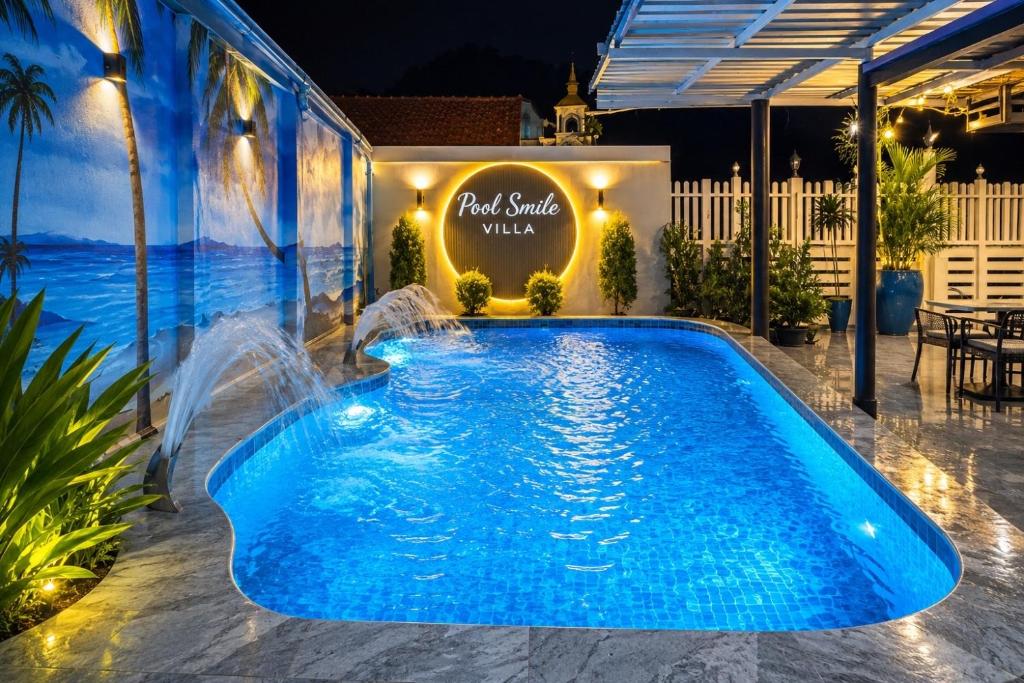 a pool at a hotel with a sign that reads real smile village at Pool Smile Villa in Bangsaen