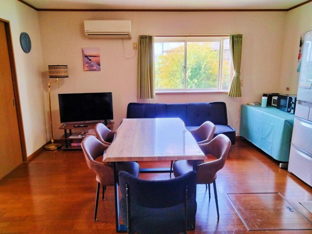 a living room with a table and chairs and a couch at Sakura Inn in Chiba