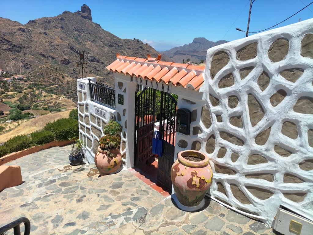 a white house with two large vases on a patio at Casita Bentayga in Tejeda