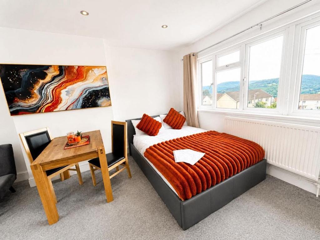 a bedroom with a bed and a table and a window at Jolly Jupiter at The Moon in Pontnewynydd