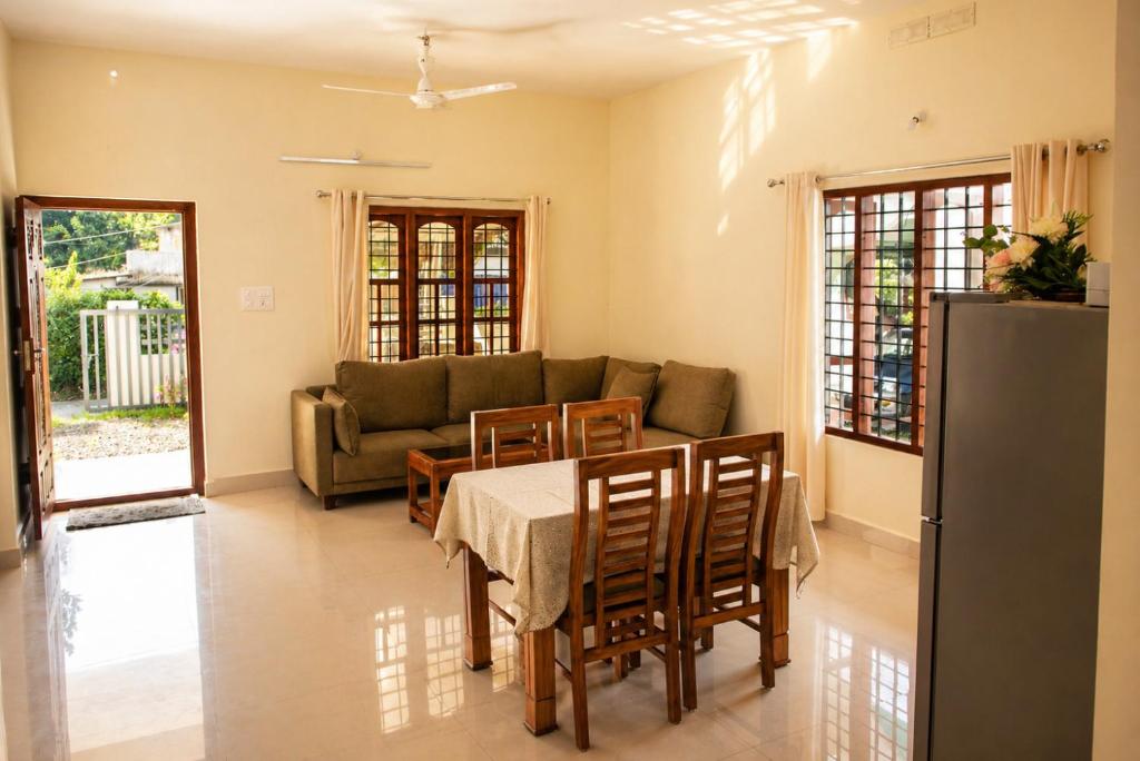 a living room with a table and a couch at Misty Leaf in Thekkady