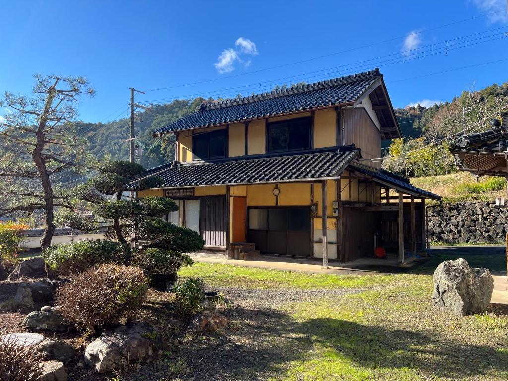 a japanese house with a mountain in the background at JIKKA KYOTO MAIZURU Private - Kominka House for Groups & Families - Vacation STAY 21302 in Kuradani
