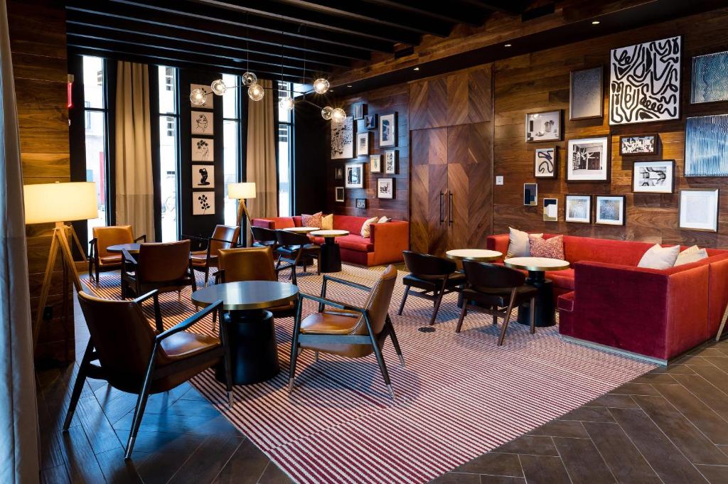 a lobby with tables and couches and chairs at Cambria Hotel Boston Somerville in Somerville