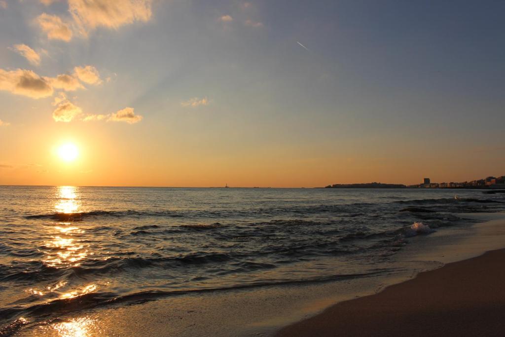 - un coucher de soleil sur une plage donnant sur l'océan dans l'établissement Triathlon B&B, à Lecce