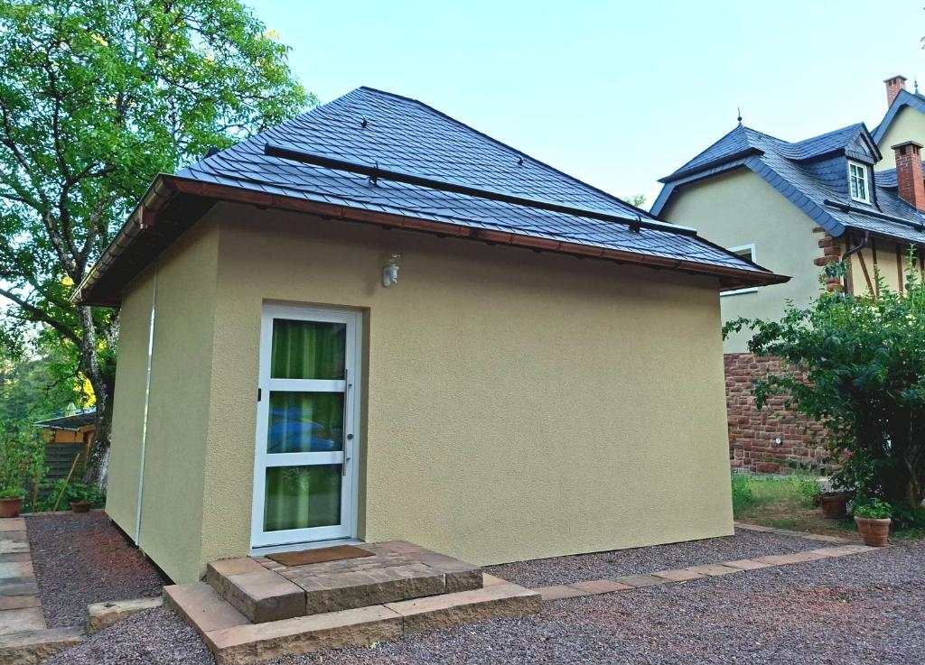 a small house with a door in a yard at Gästehaus Cube am Forsthaus in Hausbach