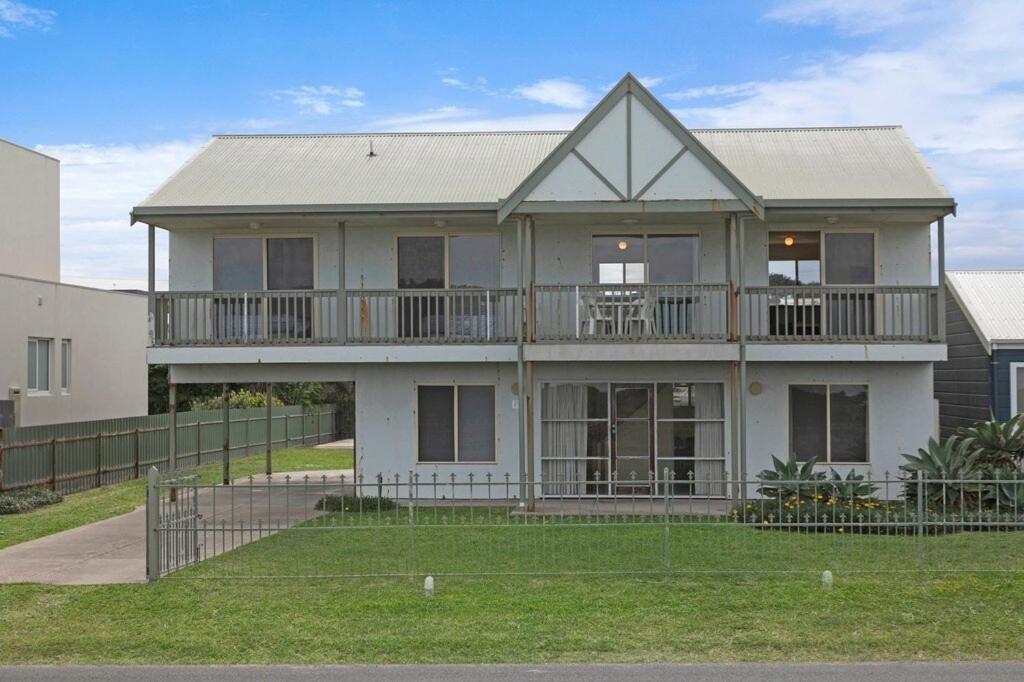 a large white house with a large balcony at Tahren Beach Getaway in Middleton