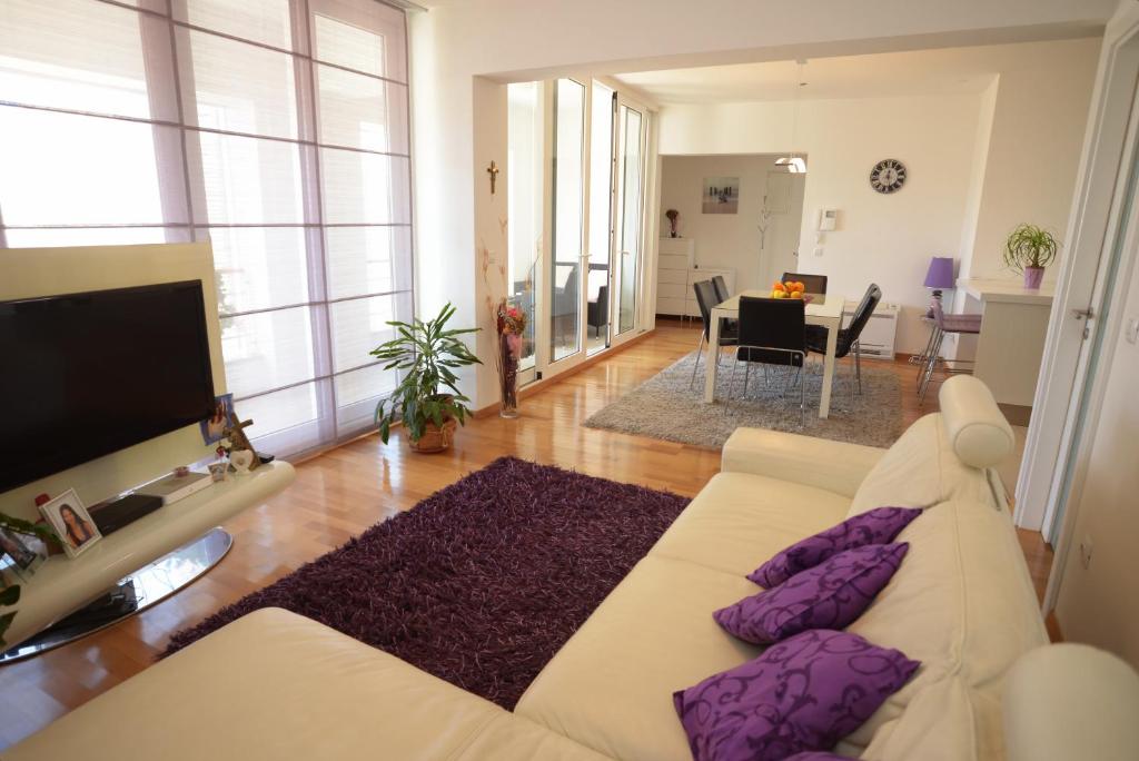 sala de estar con sofá blanco y almohadas moradas en Base Bridge Apartment - Zadar City Centre - Free parking, en Zadar