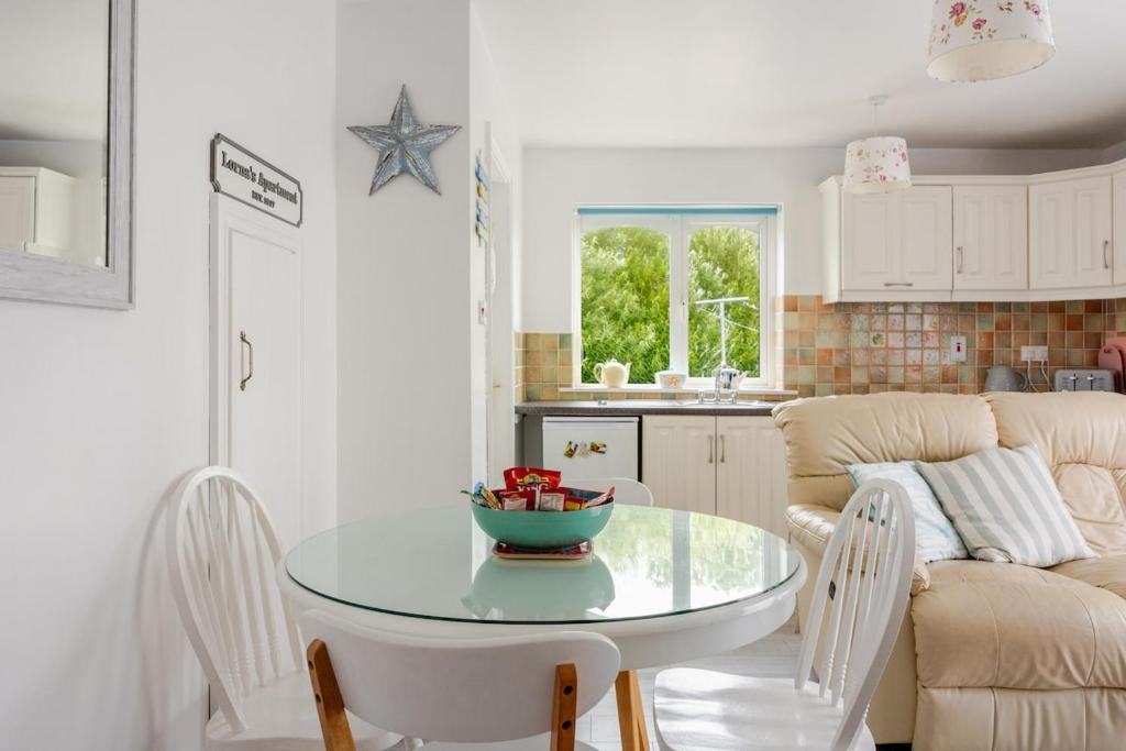 a kitchen and a table with a bowl of fruit on it at Lorna's Apartment Self Catering Holiday Home in Milltown Malbay