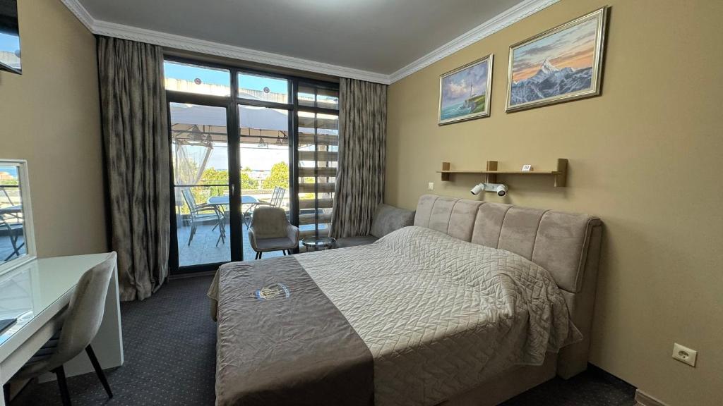 a hotel room with a bed and a desk and window at Studio Precious in Kranevo