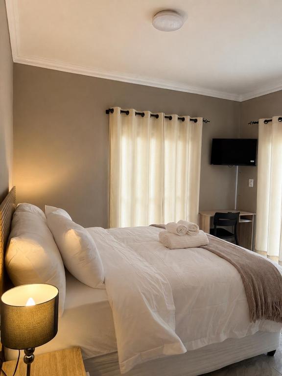 a bedroom with a white bed with towels on it at Jets Stay Property in Cape Town
