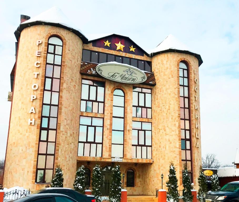 a large building with a clock on the front of it at Hotel Complex La Mezon in Samara