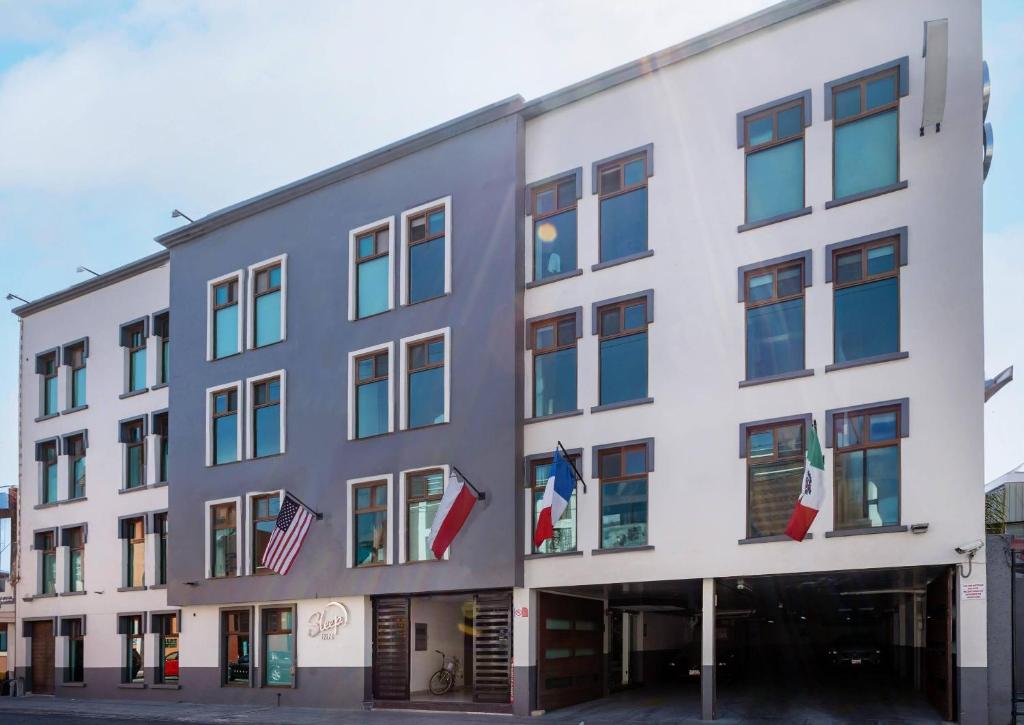 a large white building with flags on it at Sleep Inn Puebla Centro Hist rico in Puebla