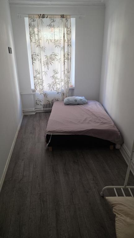 a small bedroom with a bed and a window at great apartment in Gothenburg