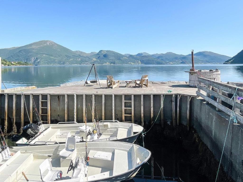 two boats are docked at a dock on a lake at 12 person holiday home in Davik in Davik