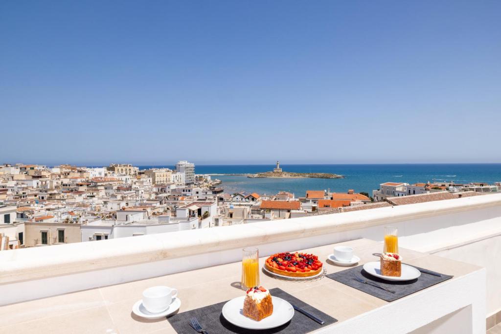 a table with two plates of food on a balcony with a view at Le 3 Viste B&B in Vieste