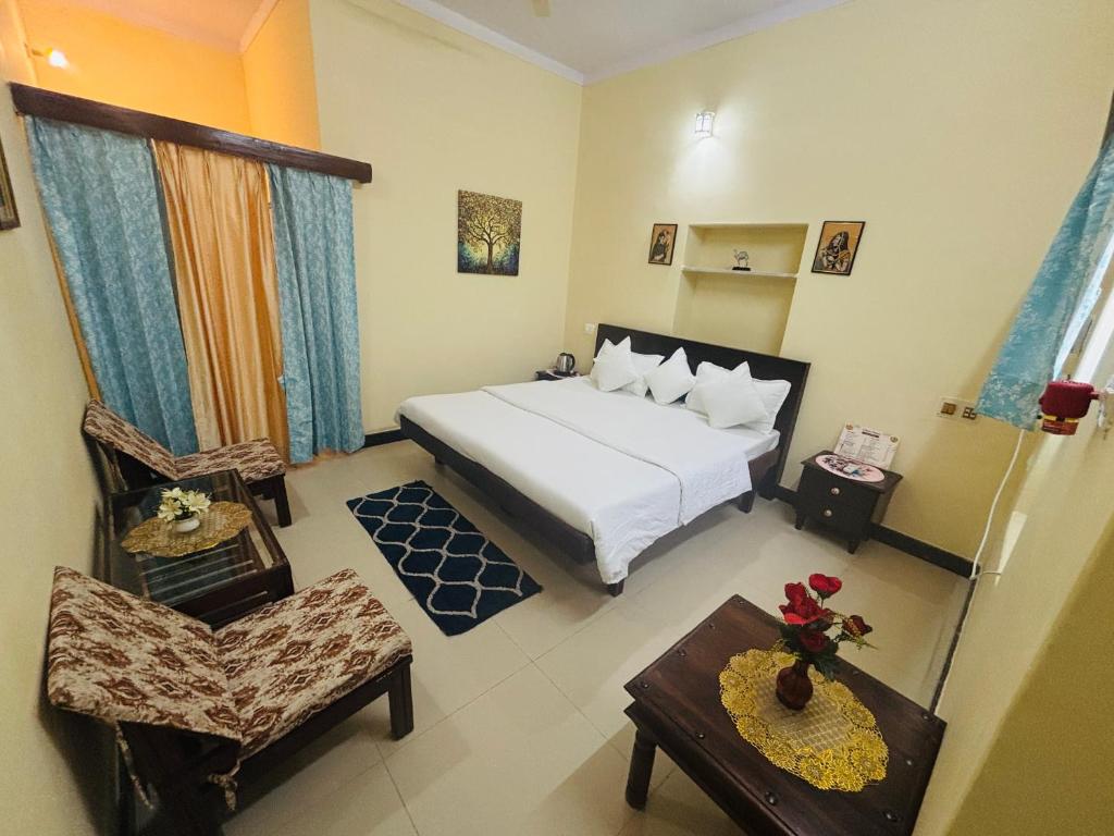 a bedroom with a bed and a chair and a table at Liliyan Palace Guest house in Jodhpur