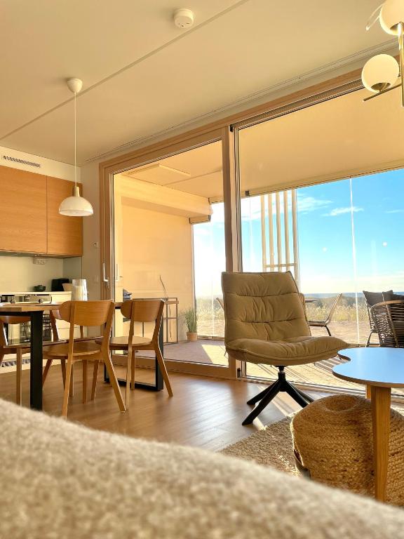 a living room with a table and chairs and a large window at Marina Sunset Resort A2 in Kalajoki