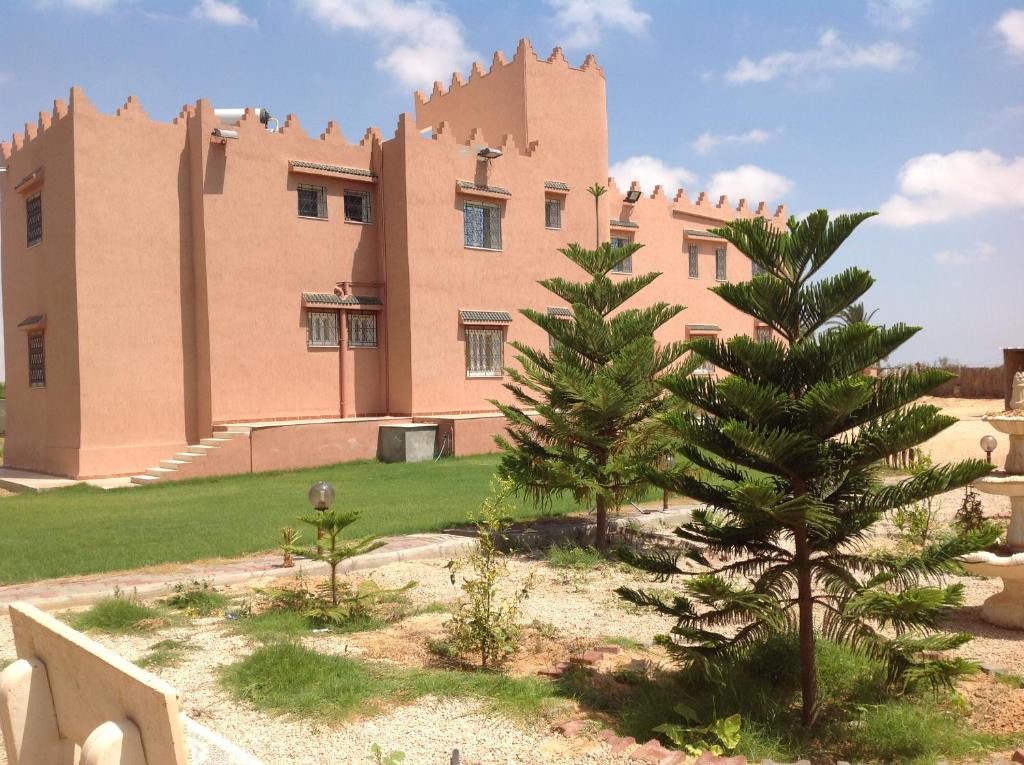 Al Medou的住宿－達爾埃爾菲達歐斯旅館，前面有棵树的建筑
