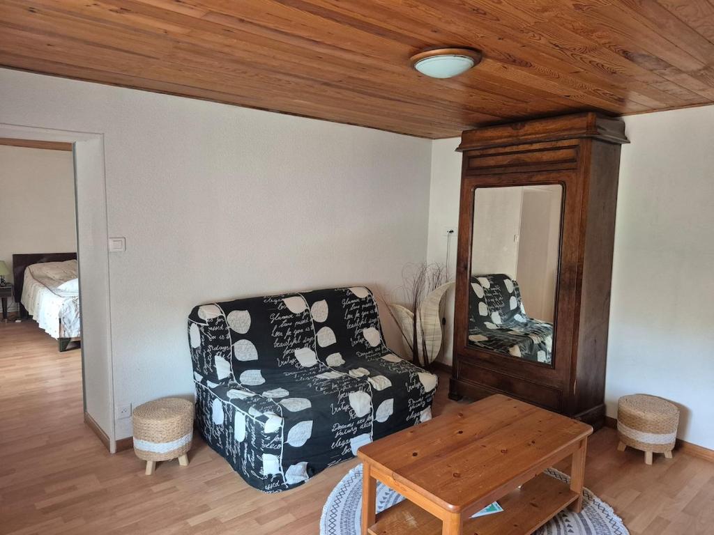 a living room with a chair and a table at La cabane de Claude in Fougerolles