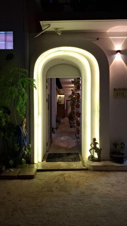 a hallway with an archway in a building at night at Sea Sun Stay in Maafushi