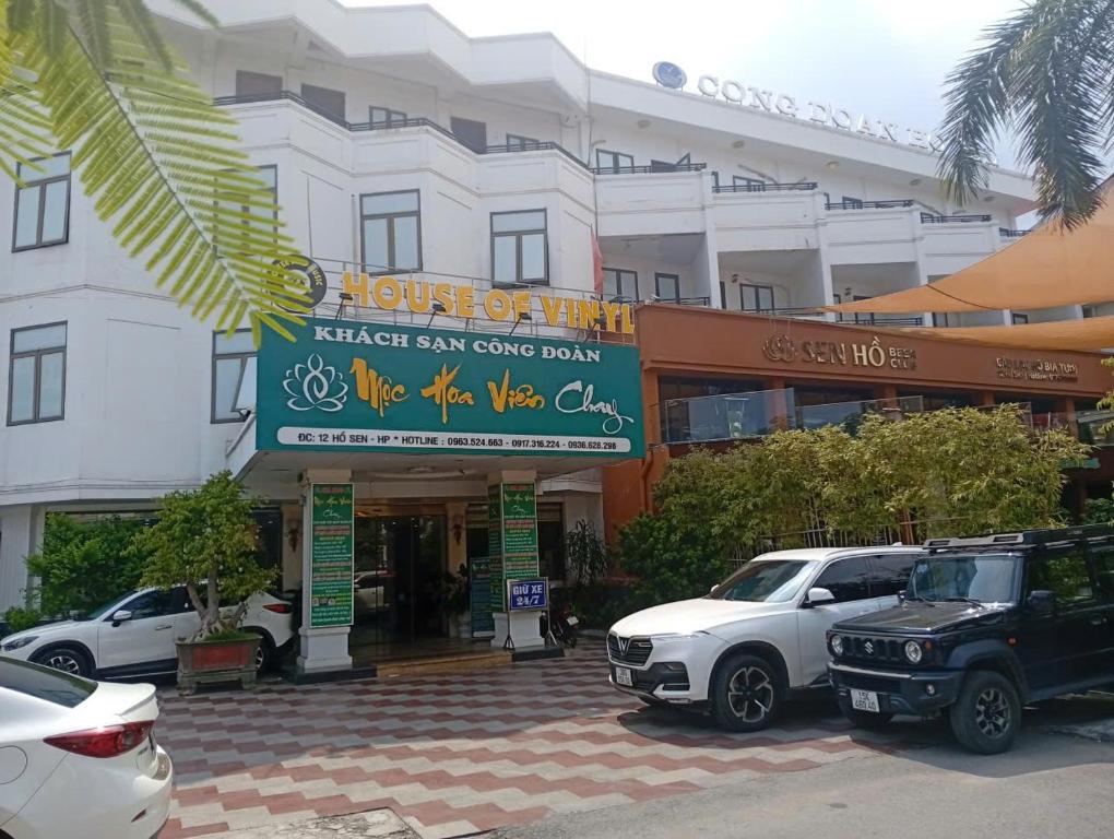 a hotel with cars parked in front of a building at Công Đoàn Hotel in Hai Phong