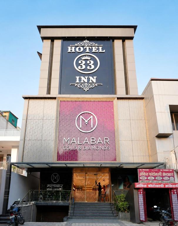 a building with a sign for a malaza bar at Hotel 33 Inn in Kānpur