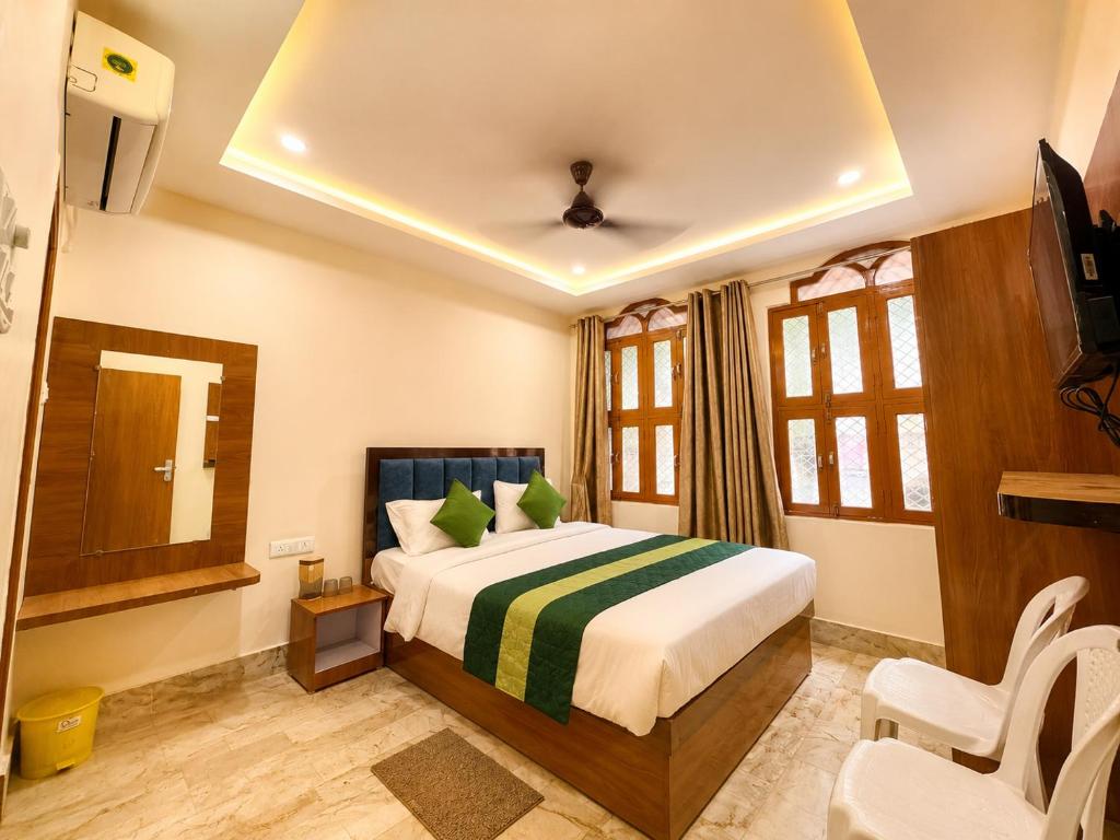 a hotel room with a bed and a television at Hotel R GUEST HOUSE - NEAR KASHI VISHWANATH TEMPLE in Varanasi