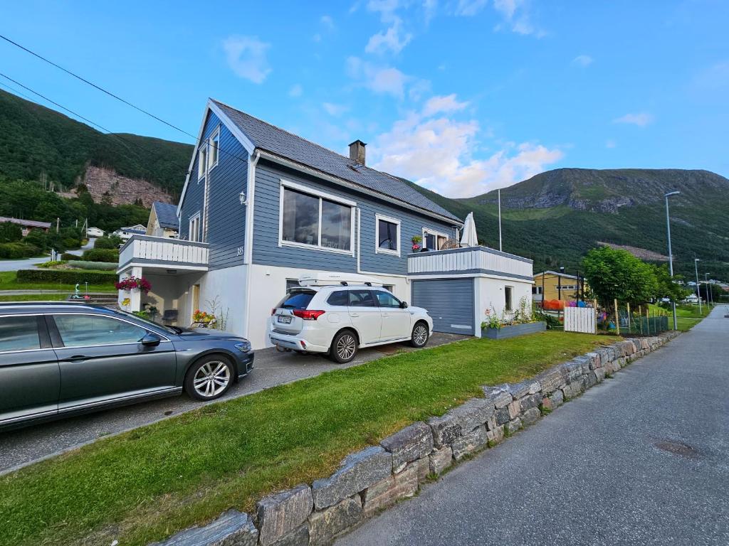 a house with two cars parked in front of it at Quiet Valley Tomrefjord in Vestnes