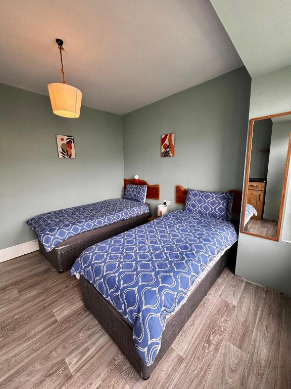 a bedroom with two beds and a mirror at Strandhill Guesthouse in Sligo