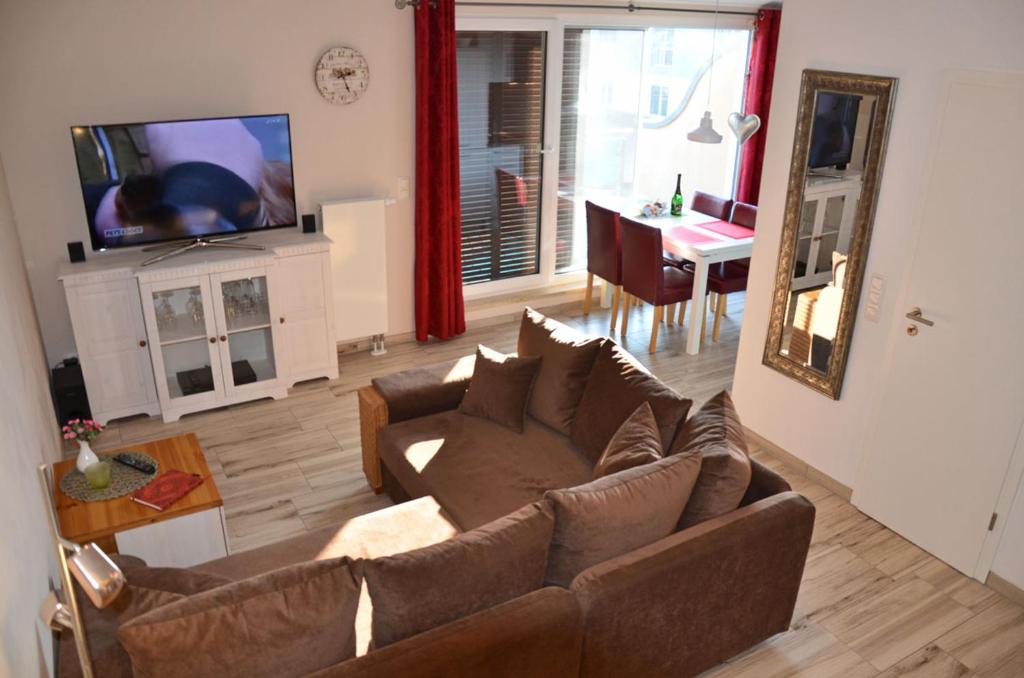 a living room with a couch and a television and a table at Bella Casa 36 - Mones in Juliusruh