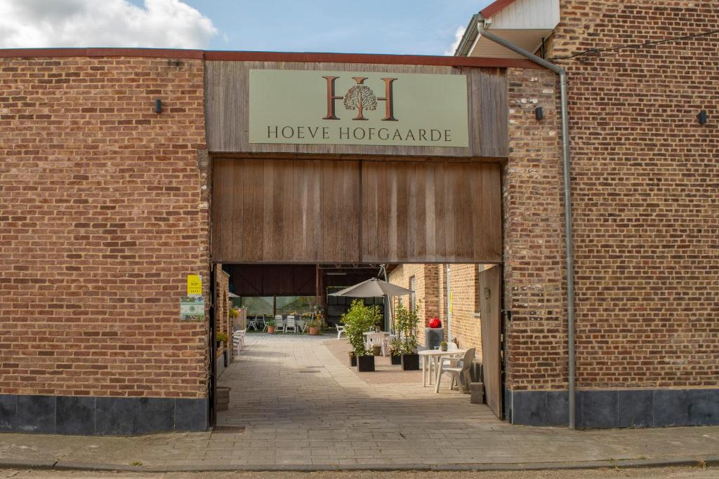 a brick building with a sign that reads hopeordable at Hoeve Hofgaarde in Heers