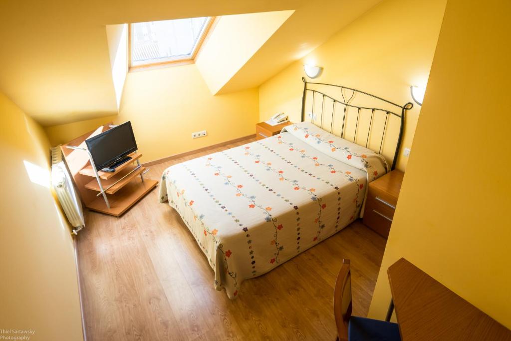 a bedroom with a bed and a desk at Hotel El Roble in Cervera de Pisuerga