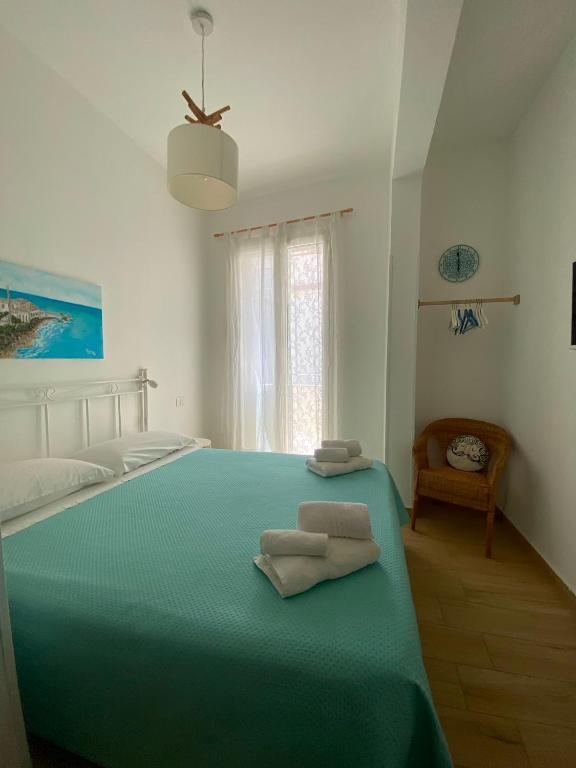 a bedroom with a green bed with two towels on it at Casa Mamà in Marzamemi