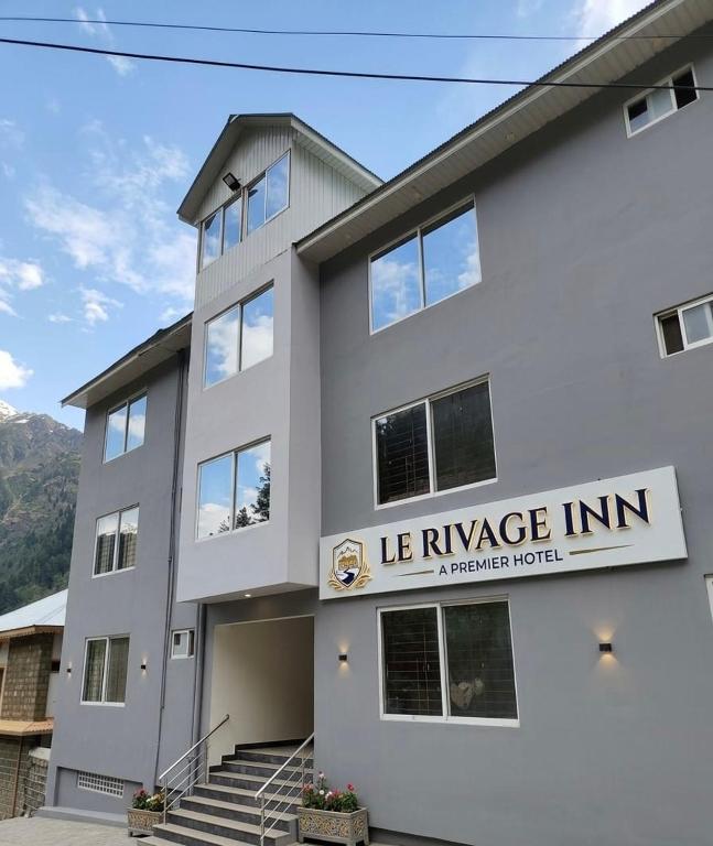 a white building with a sign that reads le refugee inn at Lee Rivage Inn in Naran