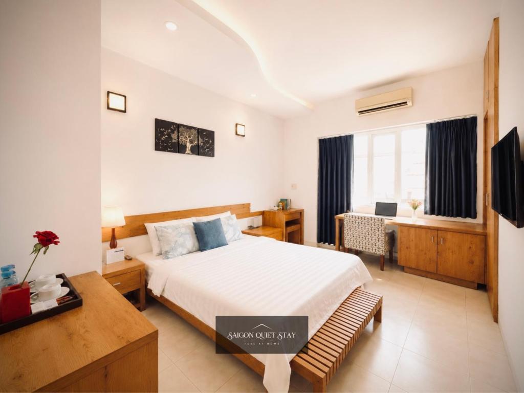 a hotel room with a bed and a desk and a room at Saigon Quiet Stay in Ho Chi Minh City