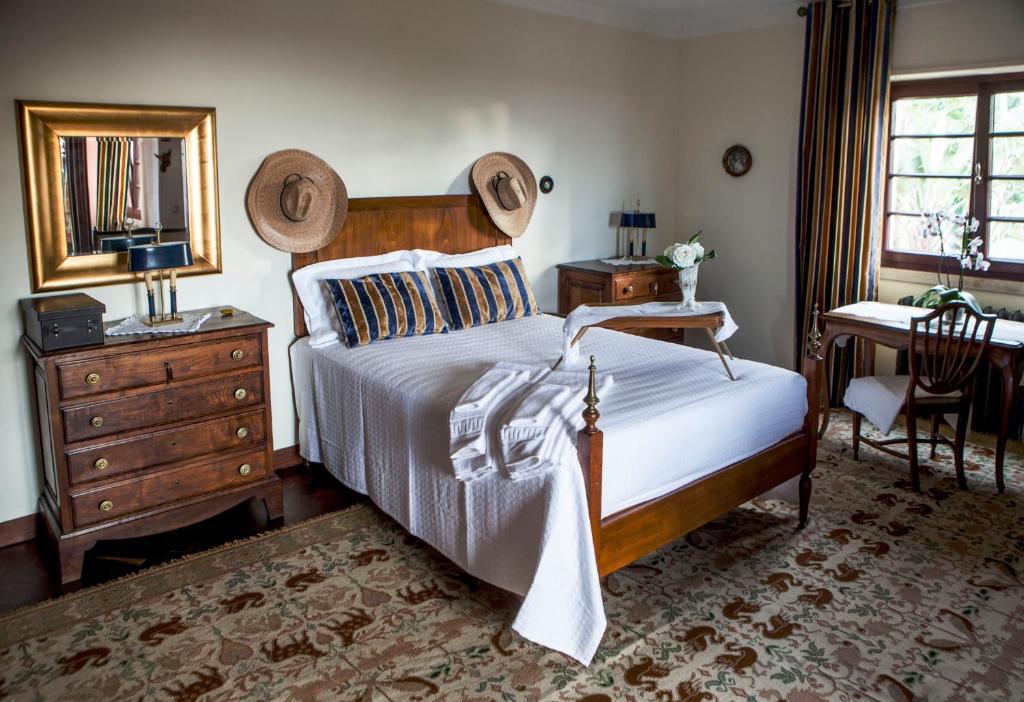 a bedroom with a bed and a desk and a mirror at Quinta Santo António in Sintra
