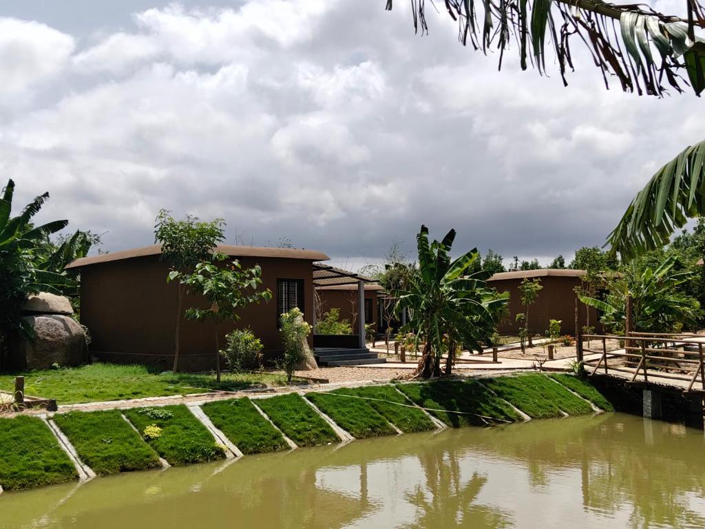 a house with a pond in front of it at Tutti Cafe in Hampi