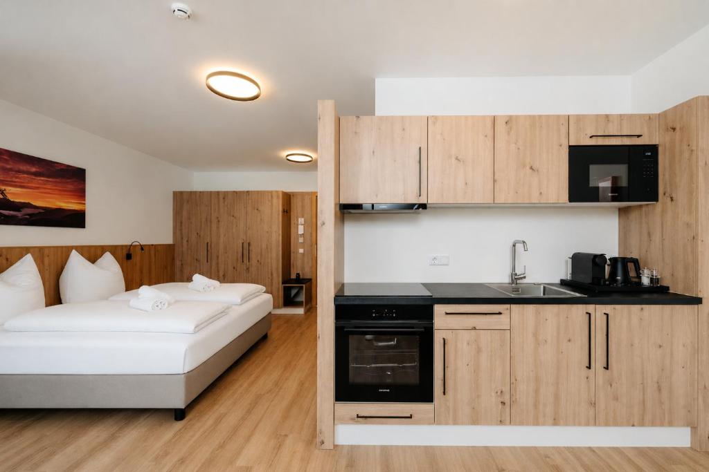 a room with a bed and a kitchen with a sink at KitzSki Living in Kitzbühel