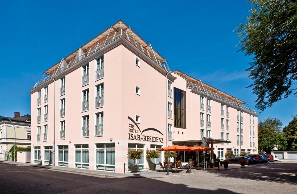 een groot wit gebouw met een bord erop bij City Hotel Isar-Residenz in Landshut
