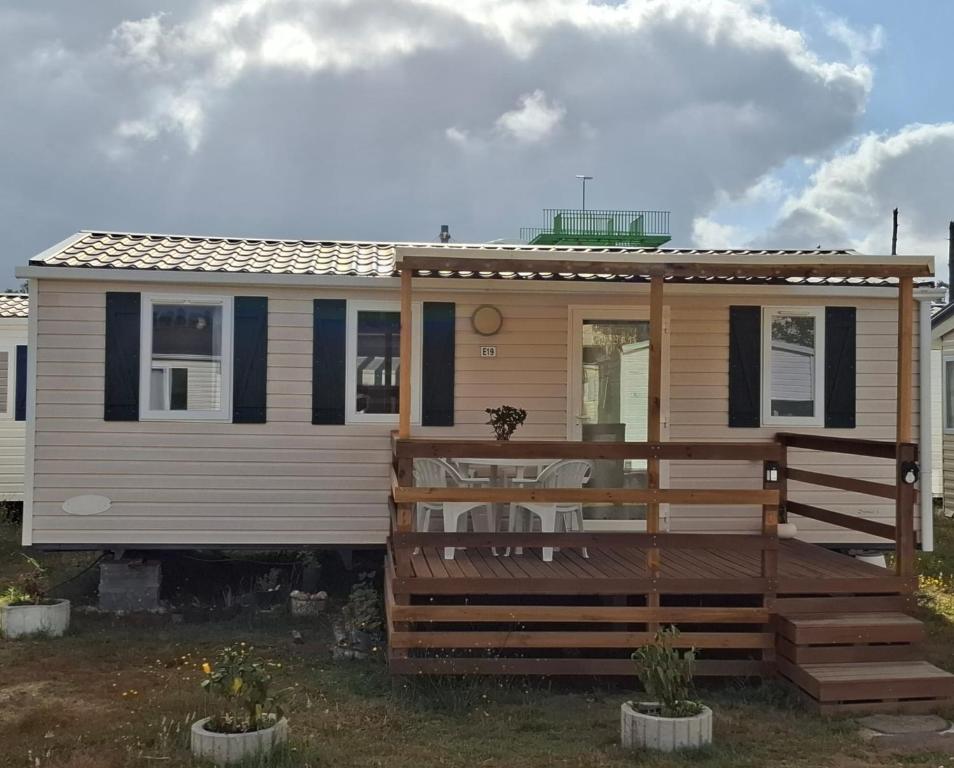 a tiny house with a deck and a porch at Cantinho da Rosa in Pataias