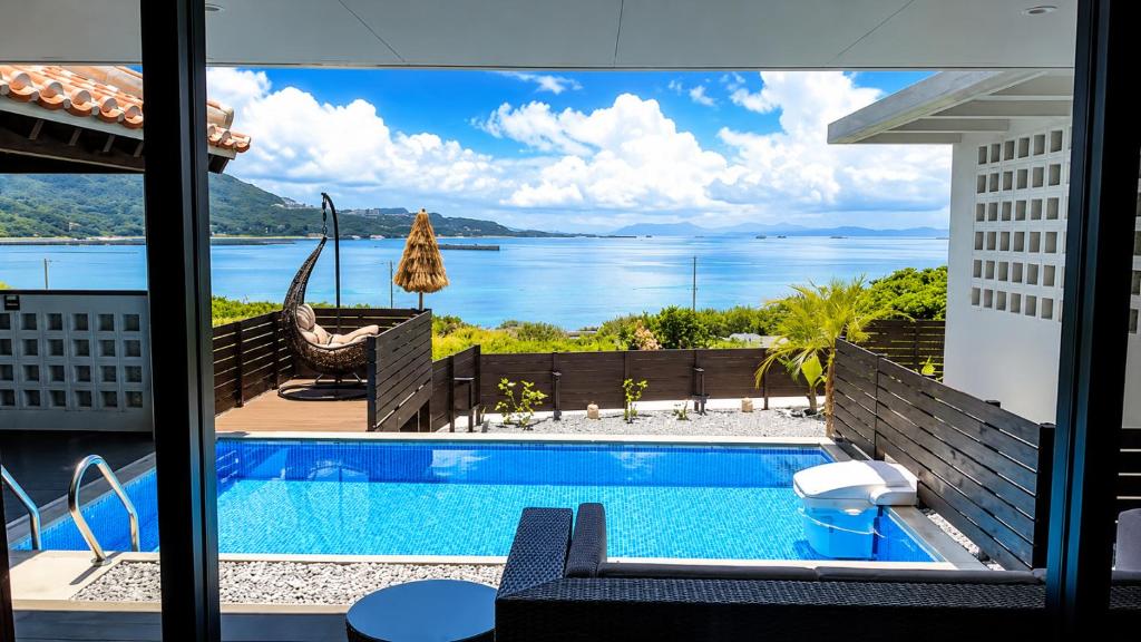a swimming pool with a view of the water at 風の音 in Motobu