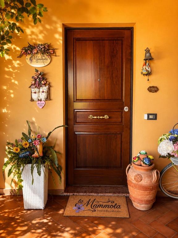 a room with a door and a vase of flowers at La Mammola Bed&Breakfast in Fabriano
