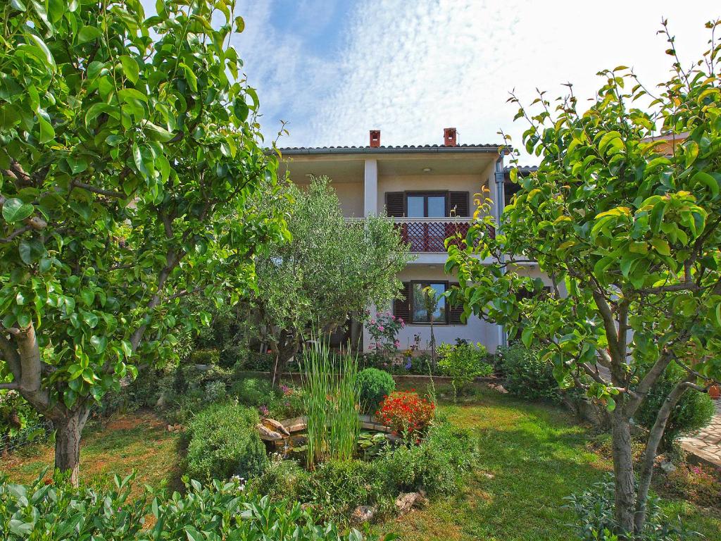 una casa en medio de un jardín con árboles en Apartments Lavanda 108, en Fažana