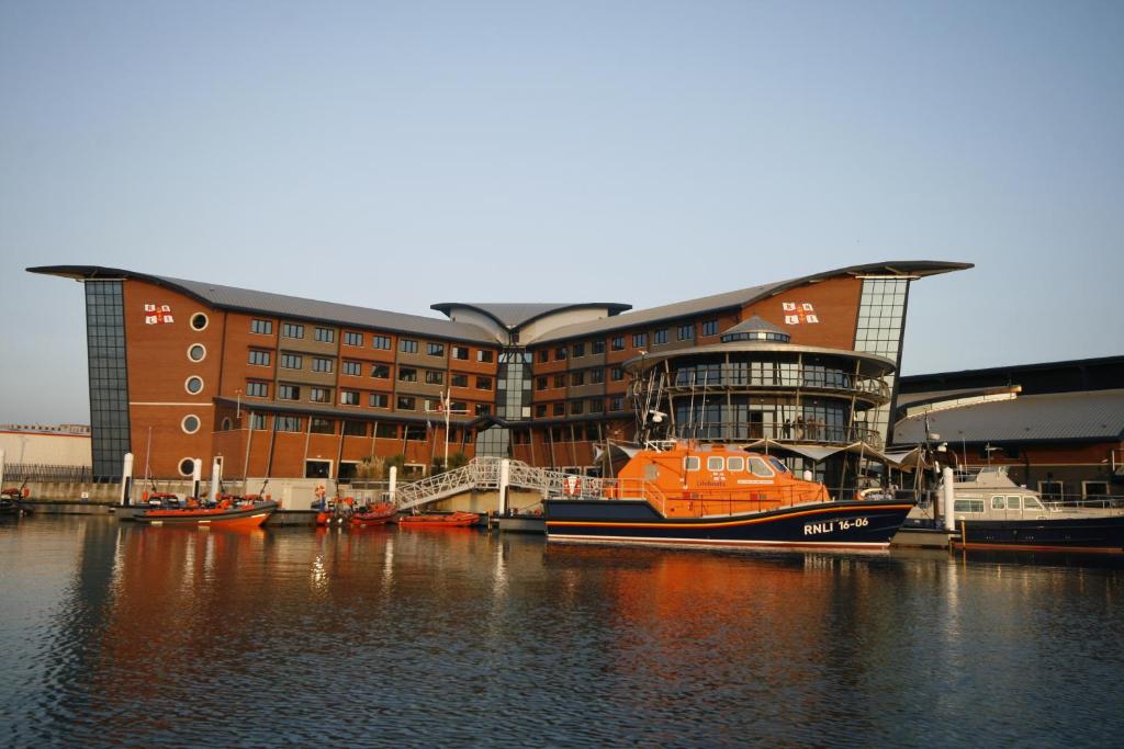 a boat is docked in front of a building at RNLI College in Poole